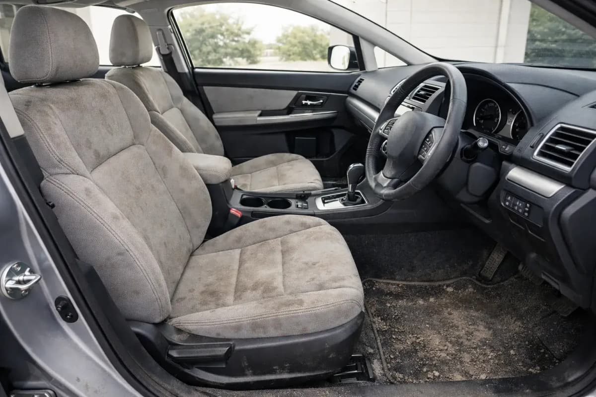 Luxury car interior before detailing in Chennai showing dust and grime